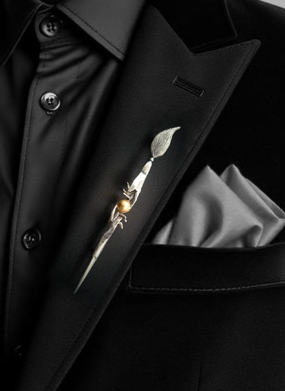 Commission paintbrush brooch worn on a lapel